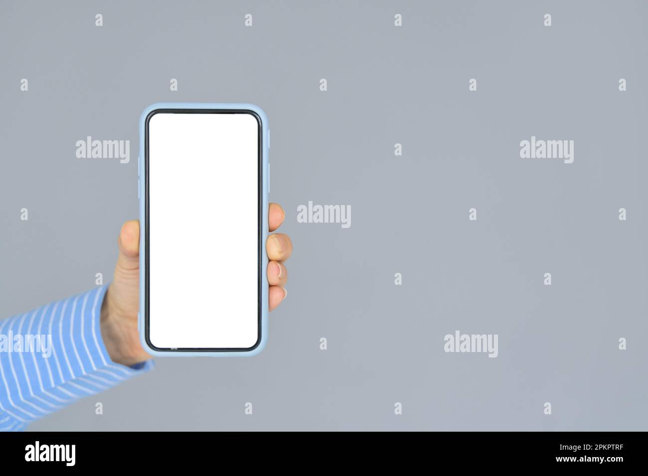 Mano femmina che tiene il telefono cellulare con schermo mobile bianco mock up. Primo piano Foto Stock