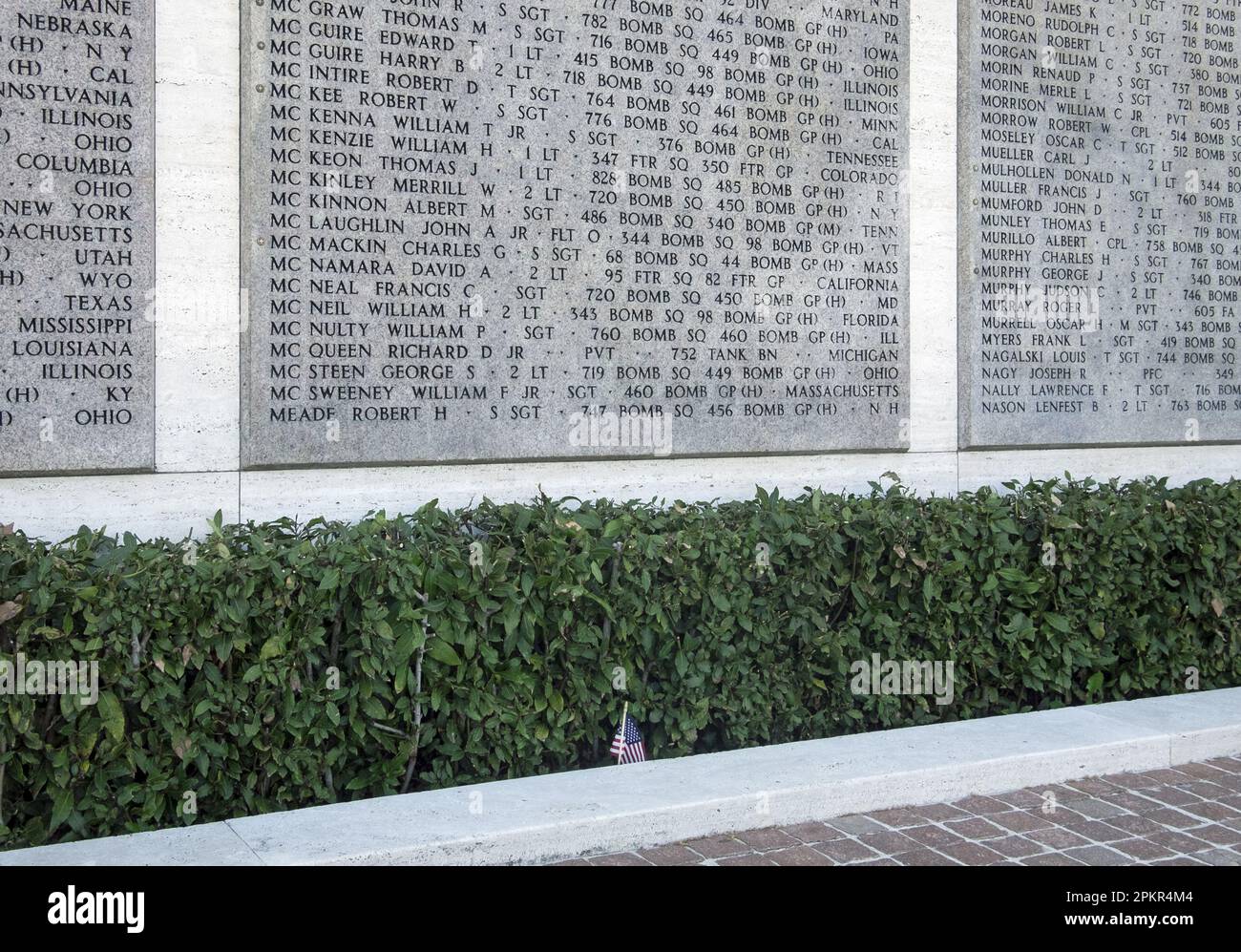 Nomi dei soldati caduti al cimitero americano di Firenze, Impruneta, Italia con una piccola bandiera americana sul marciapiede Foto Stock