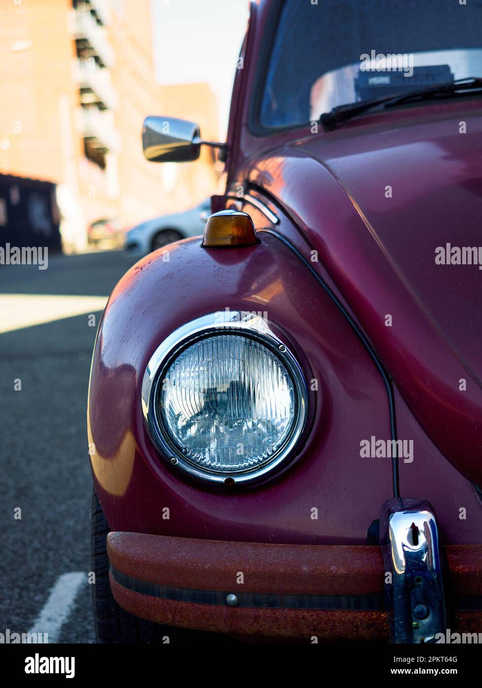 Iverpool UK Aprile 2023 Un anfratto e vintage VW Beetle si trova su una strada cittadina, il suo classico faro e lo stile retrò Foto Stock