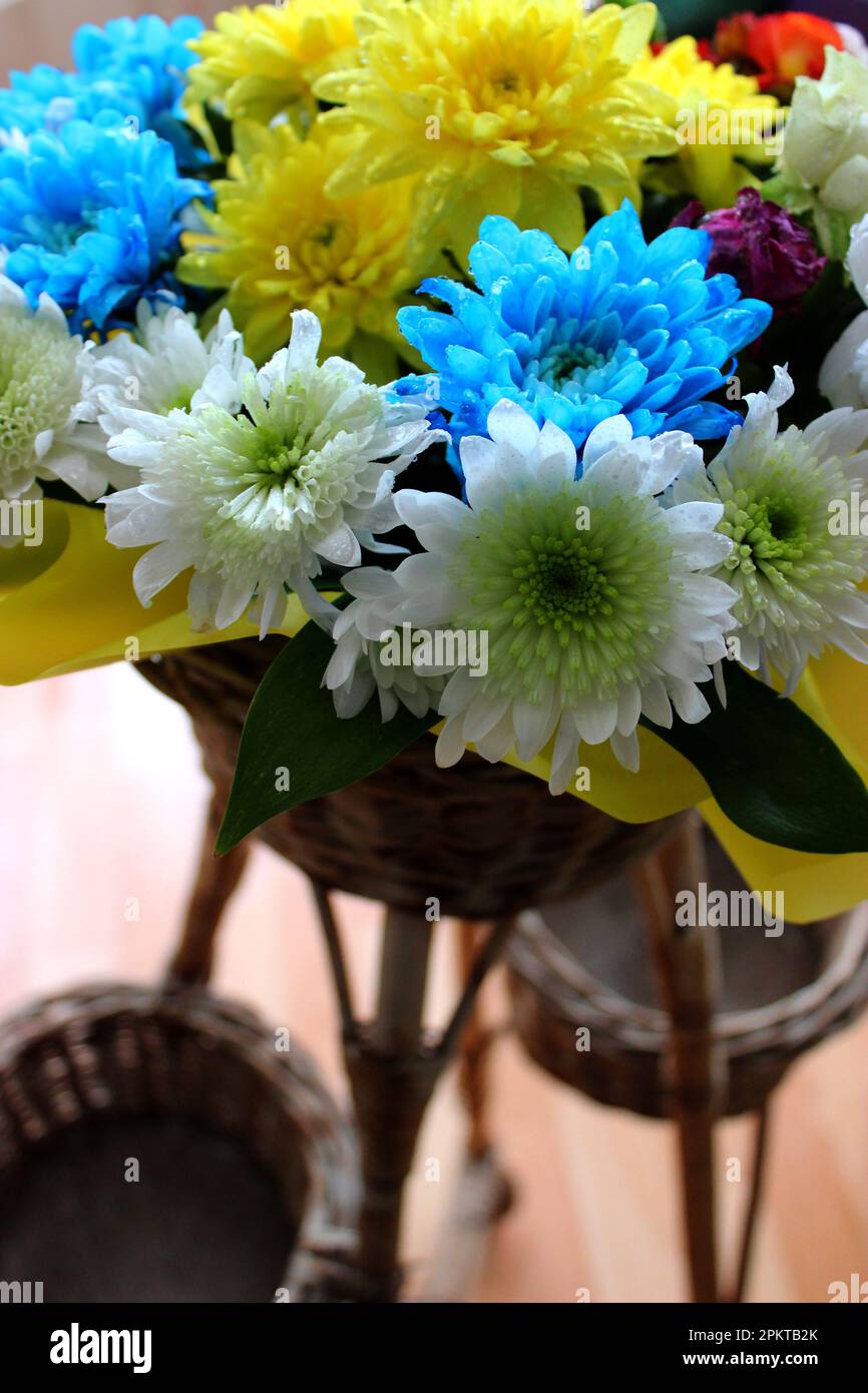 Rattan rack con bouquet di fiori freschi in carta imballata in Un negozio di fiori foto d'archivio per la storia verticale Foto Stock