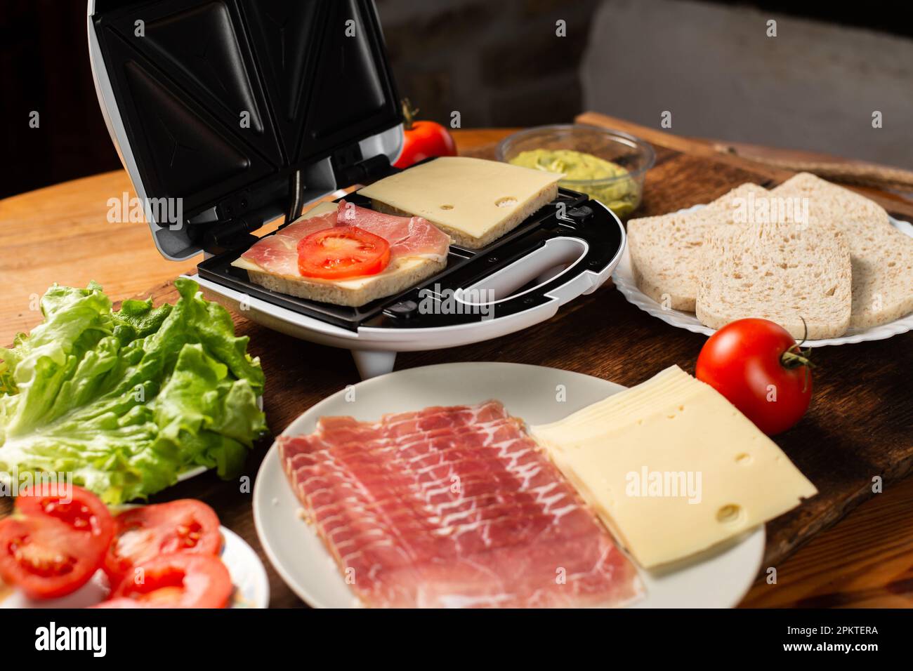 Macchina per sandwich. Cottura di panini con farciture diverse. Foto Stock