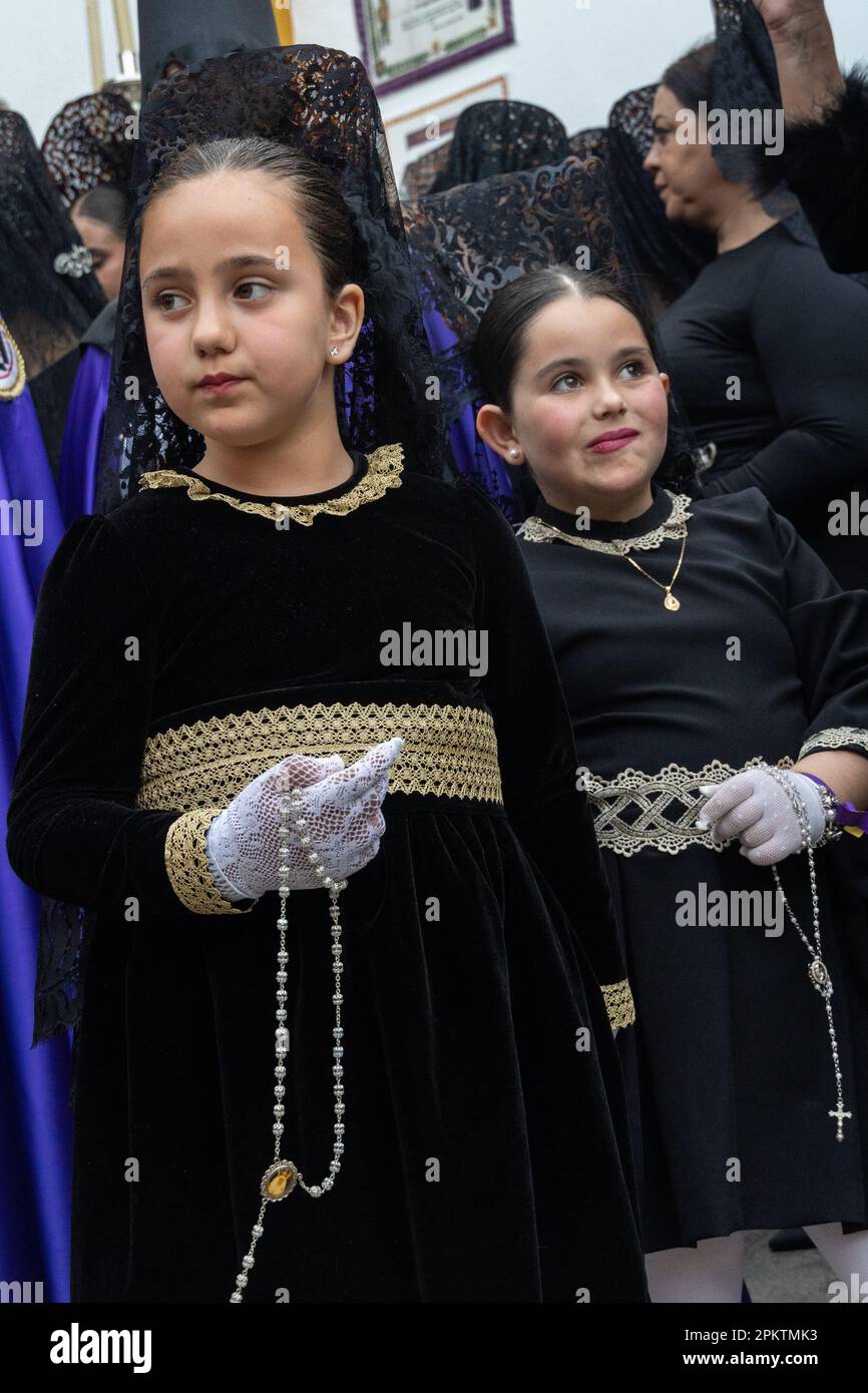 Setenil de las Bodegas, Spagna. 08th Apr, 2023. Le giovani ragazze spagnole che indossano il tradizionale merletto liturgico mantilla e i pettini alti della peineta, si preparano per una processione durante la settimana Santa, conosciuta come Semana Santa, 8 aprile 2023 a Setenil de las Bodegas, Spagna. I residenti del piccolo villaggio di Setenil hanno vissuto in case grotta fin dal neolitico. Credit: Richard Ellis/Richard Ellis/Alamy Live News Foto Stock