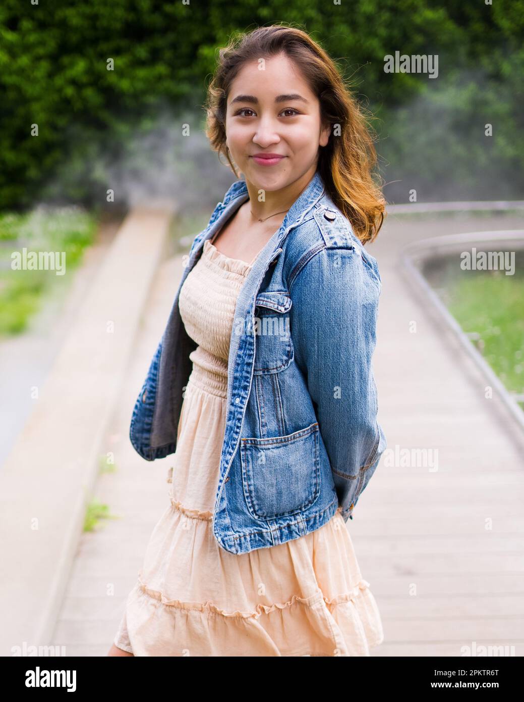 Asian Teen Walking on Misty Walkway | De Young Museum Gardens | Female | giacca in denim con abito corto Foto Stock