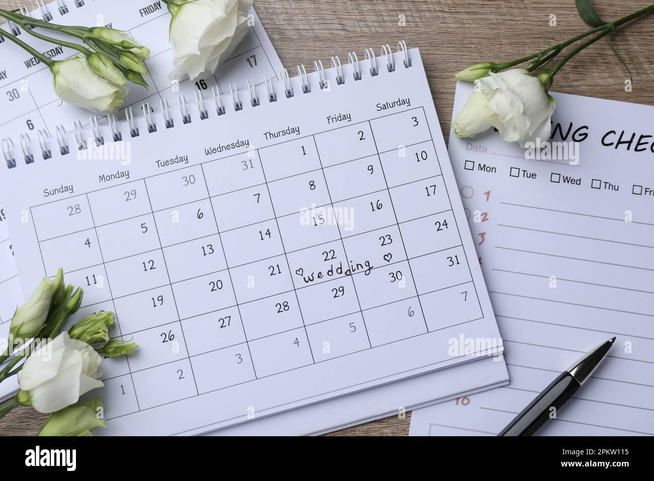 Composizione di posa piatta con lista di controllo per matrimoni e calendari su tavolo di legno Foto Stock
