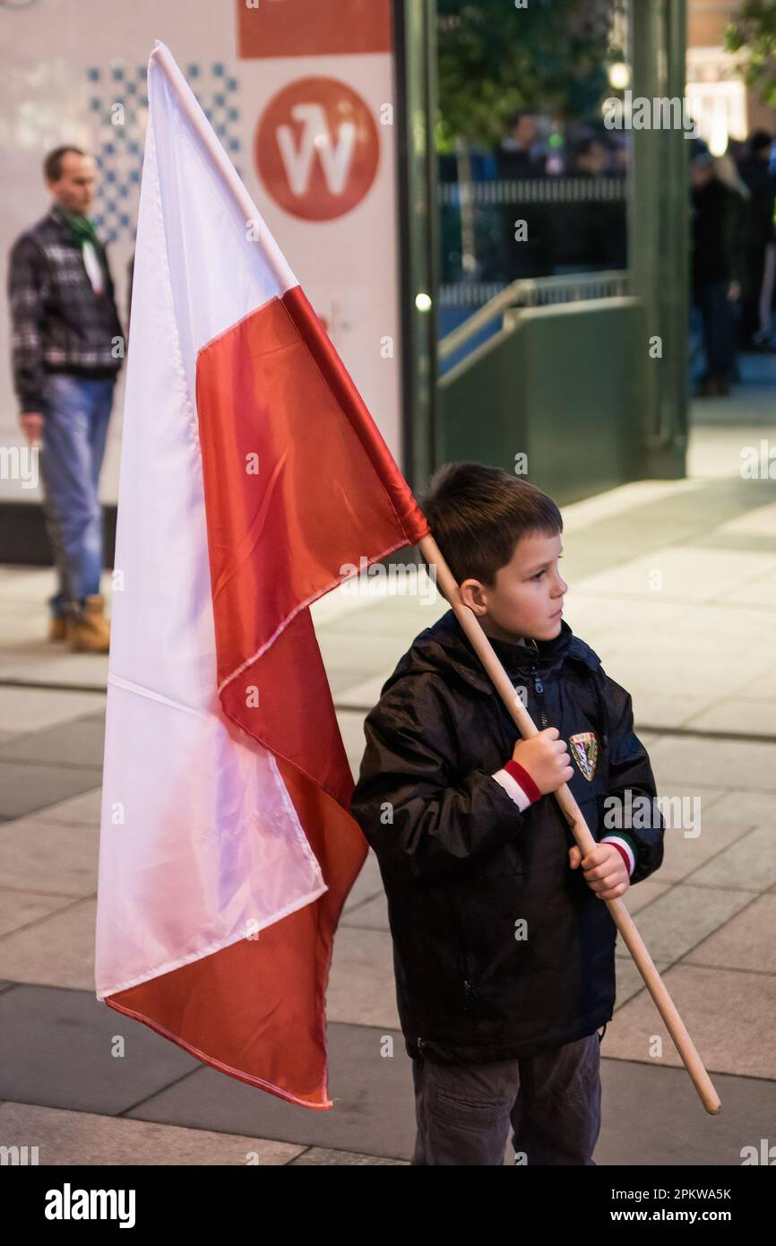 Il giovane ragazzo tiene una bandiera polacca durante la protesta. Il 11 novembre, Giornata dell'Indipendenza Polacca, è stata organizzata la Grande marcia dell'Indipendenza. I manifestanti chiedono un ritorno ai valori e all'identità tradizionali polacchi, invocando spesso il cattolicesimo e il nazionalismo come parti importanti della loro visione del mondo. Molti di loro sottoscrivono ideologie politiche di estrema destra e sono affiliati con organizzazioni come la rinascita nazionale della Polonia e gli hooligan polacchi della gioventù e del calcio. Tuttavia, va notato che non tutti i partecipanti alla marcia possono avere opinioni estreme o intolleranti, e così è stato Foto Stock
