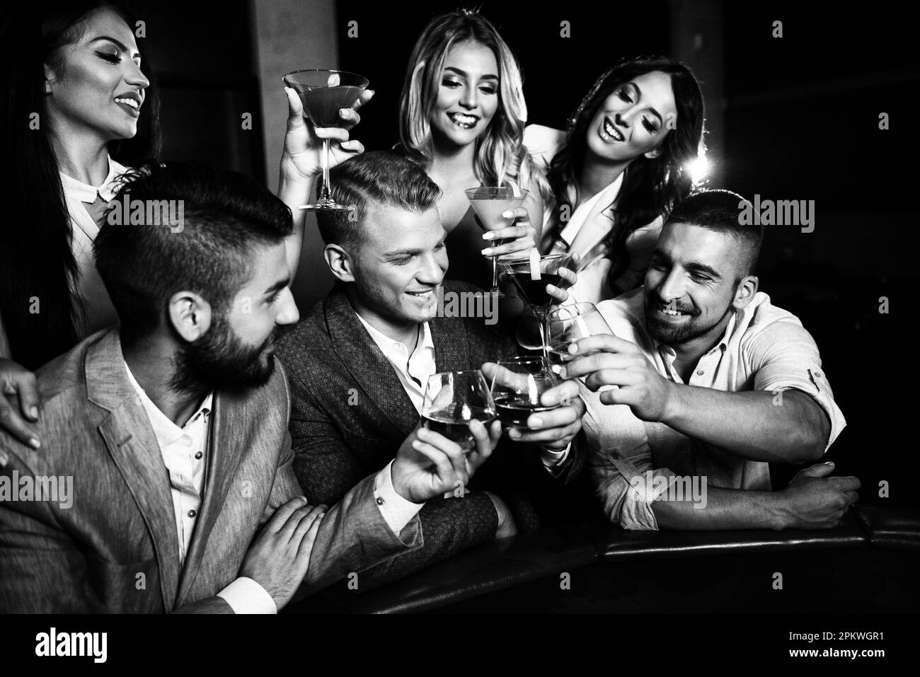 Coppia bella e ben vestita giocando Roulette nel Casinò e bere alcolici per festeggiare Foto Stock