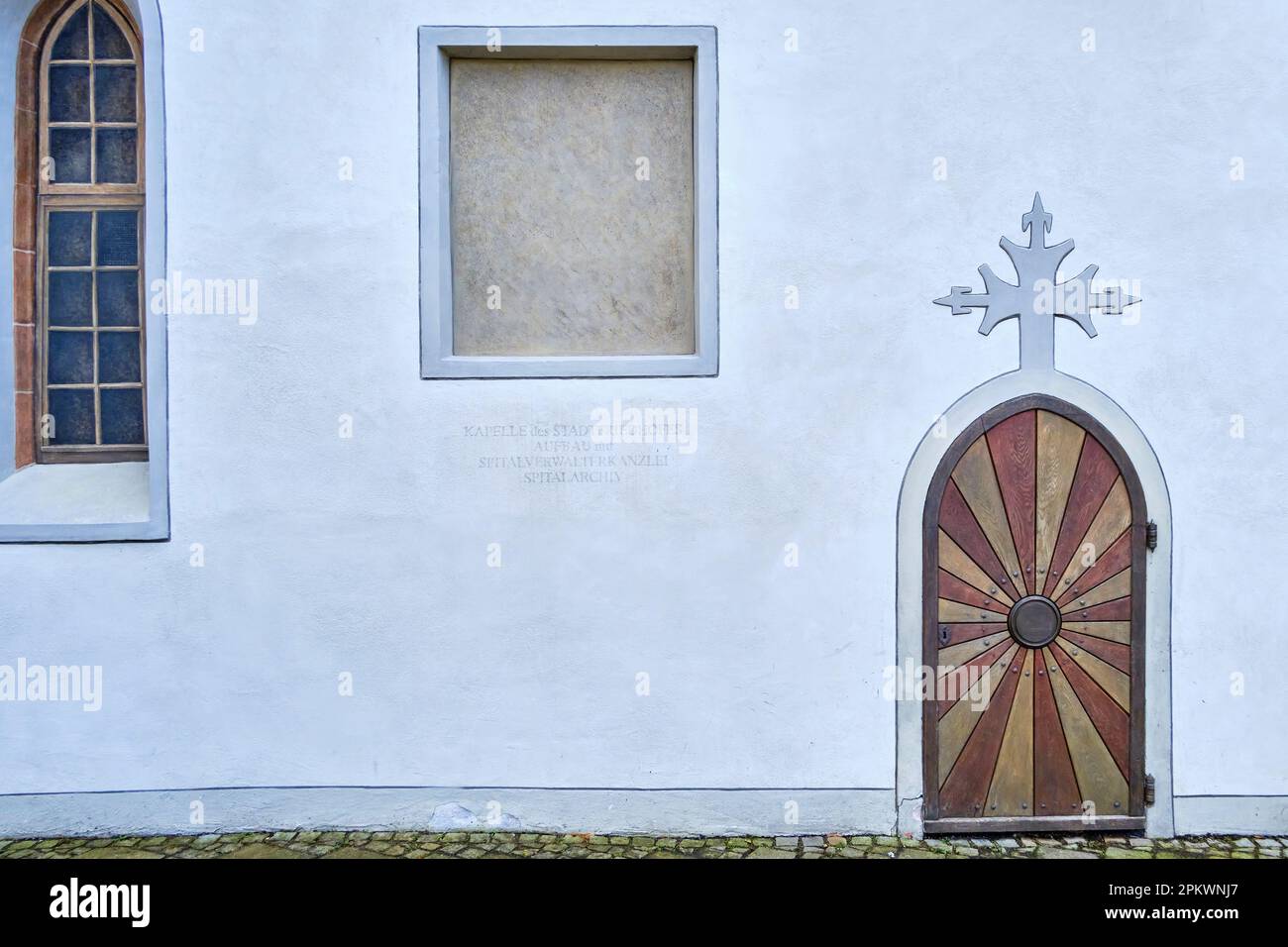 Porta ad arco con croce in cima all'arco, cappella cittadina di Blaubeuren vicino Ulm, Baden-Wurttemberg, Germania, Europa. Foto Stock