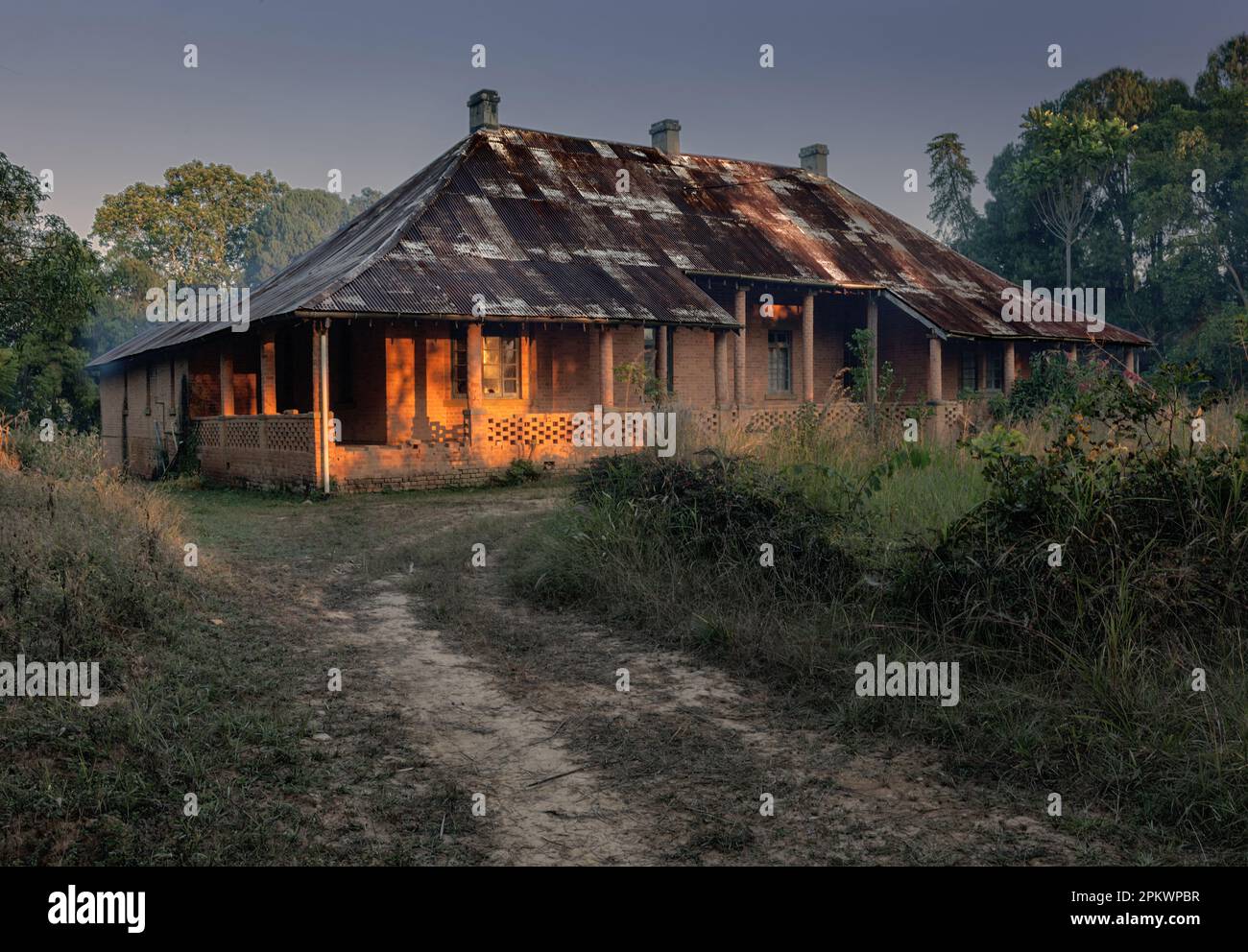 La prima luce del mattino cattura la veranda di una vecchia casa coloniale nel villaggio missionario di Livingstonia nel nord del Malawi. Foto Stock