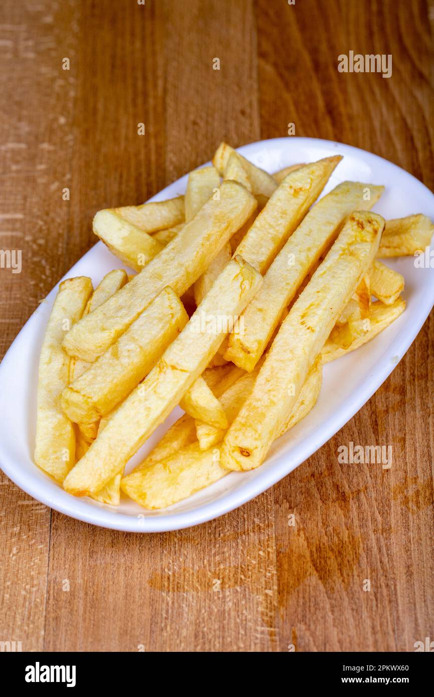 Patate fritte o patatine fritte. Patatine fritte sbucciate a mano in un recipiente in ceramica. primo piano Foto Stock