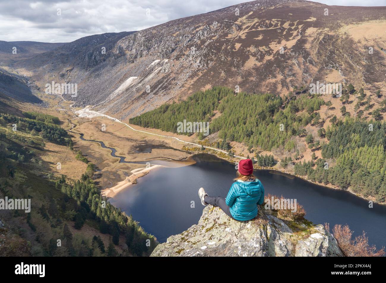 Escursionista femminile seduto godendo il paesaggio a Glendalough Irlanda Foto Stock