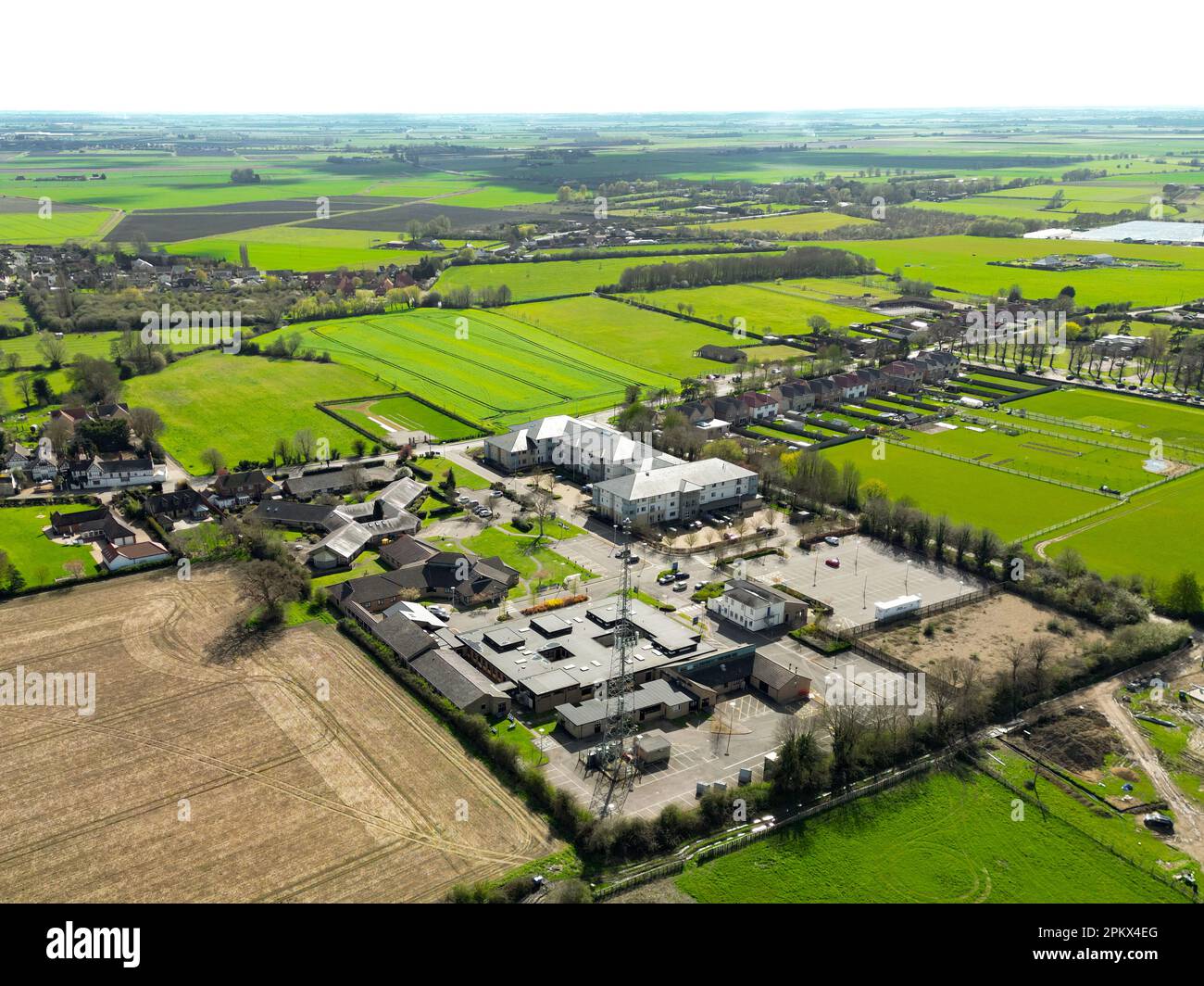 Vista drone di un moderno ospedale NHS comunità che mostra i vari edifici moderni e alto sistema di antenne. Servire la comunità rurale locale. Foto Stock