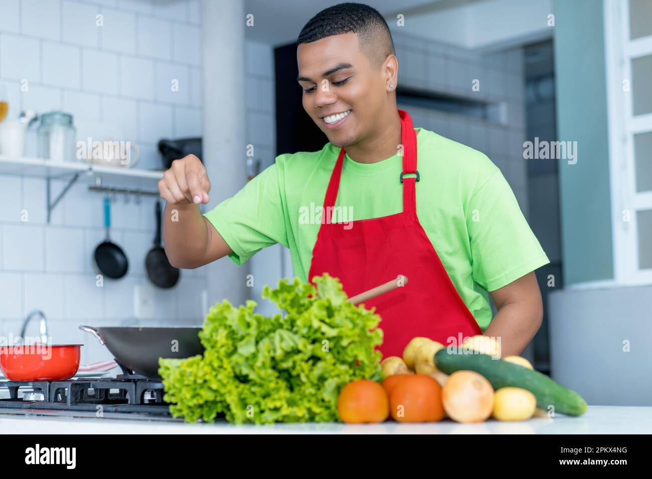 Motivati apprendista chef latino-americani che preparano piatti vegetariani o vegani nella cucina del ristorante Foto Stock