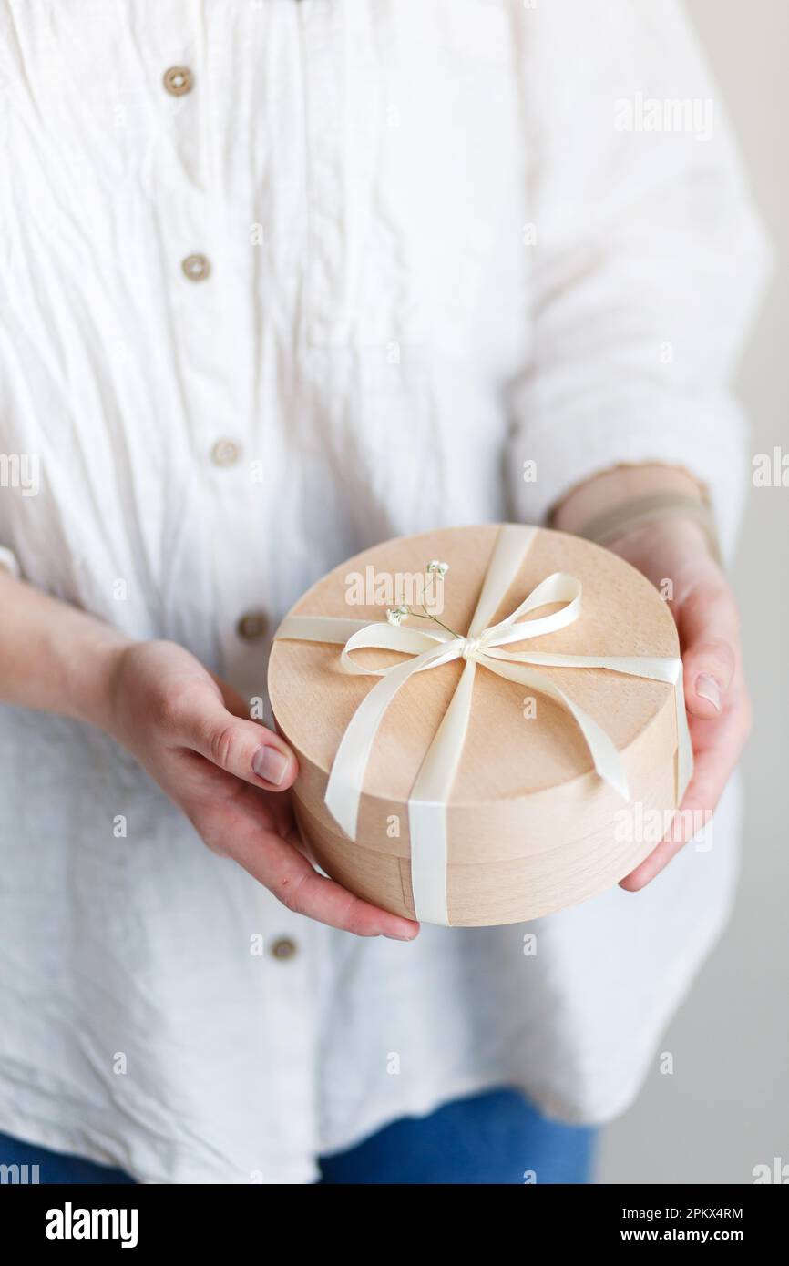 l'imprenditore del pasticciere della ragazza tiene il giftbox nelle sue mani Foto Stock