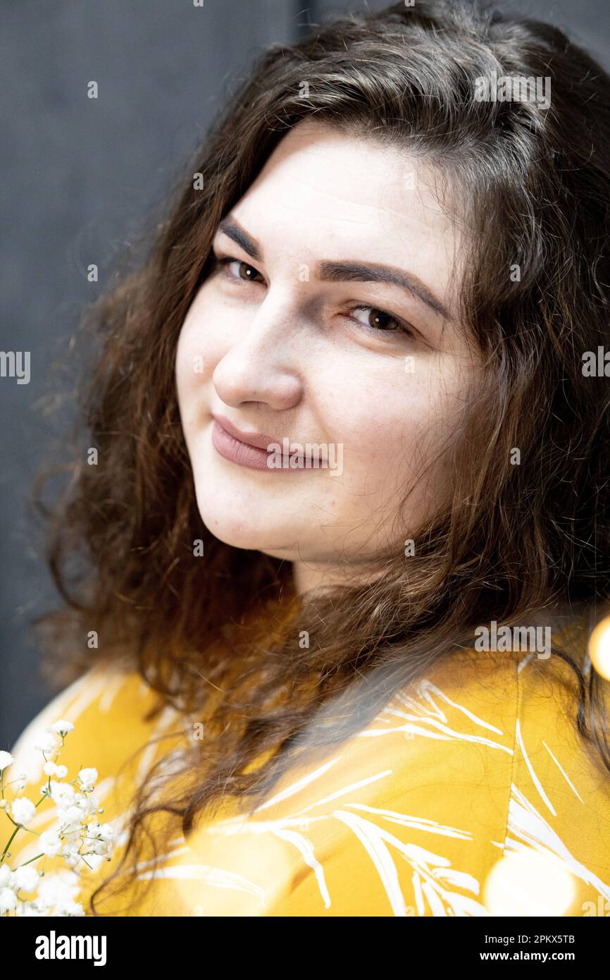 Una ragazza in una T-shirt gialla con un bouquet di piccoli fiori bianchi Foto Stock
