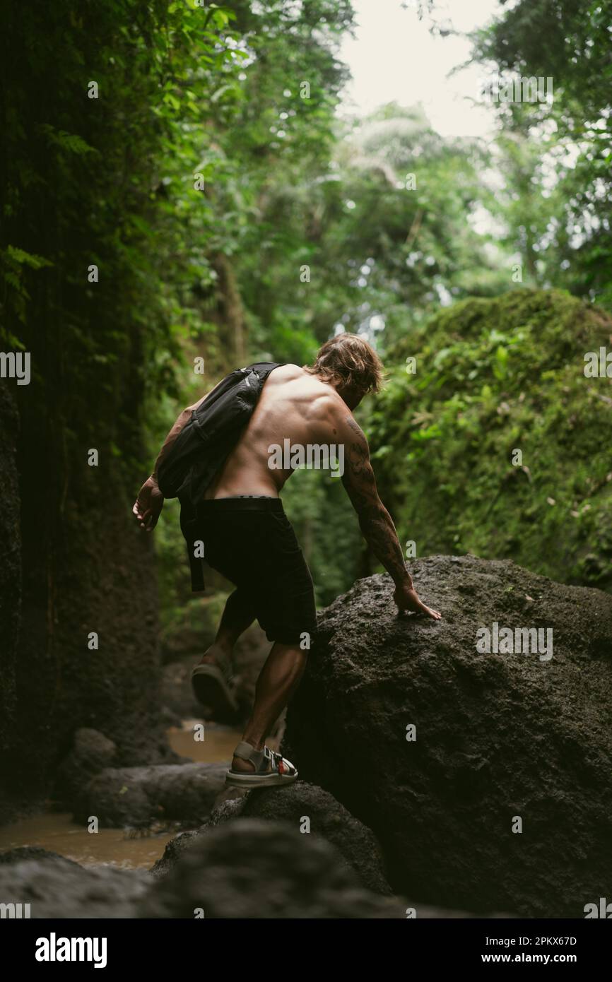 Un giovane viaggia attraverso le giungle tropicali di Bali. Foto Stock