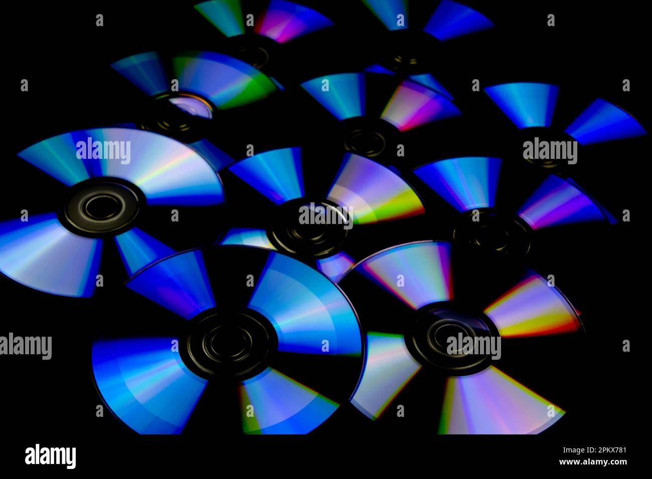 CD e DVD isolati su sfondo nero con riflessi colorati Foto Stock