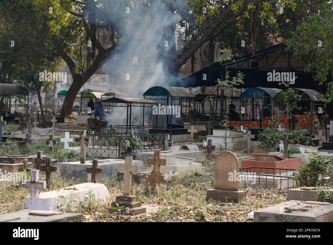 I rifiuti sono bruciati al cimitero cristiano indiano, Paharganj, Nuova Delhi, India Foto Stock