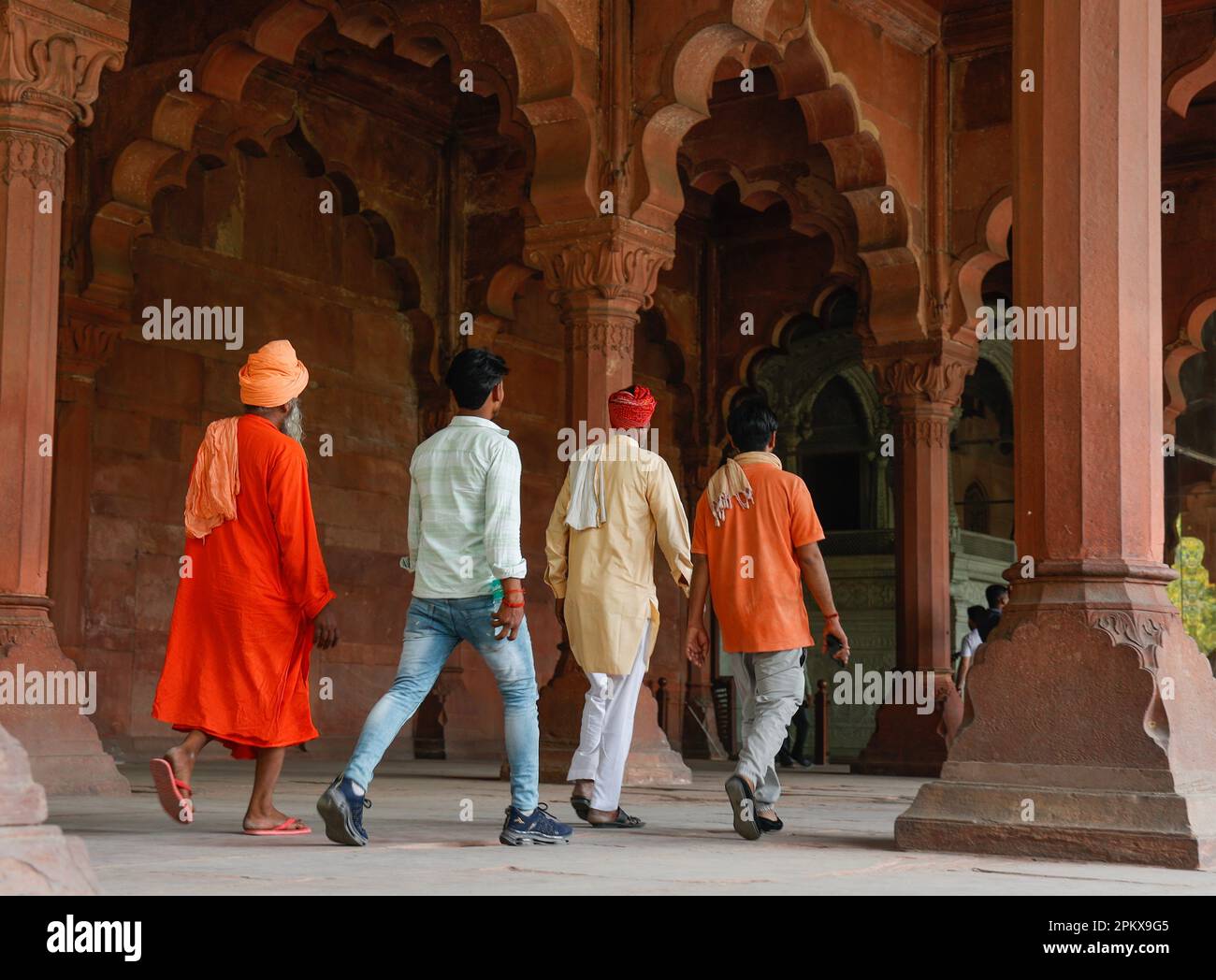 Turisti indiani che camminano attraverso i colonnati di pietra di sabbia rossa di Diwan-i-AMM nel Forte Rosso, Delhi, India Foto Stock