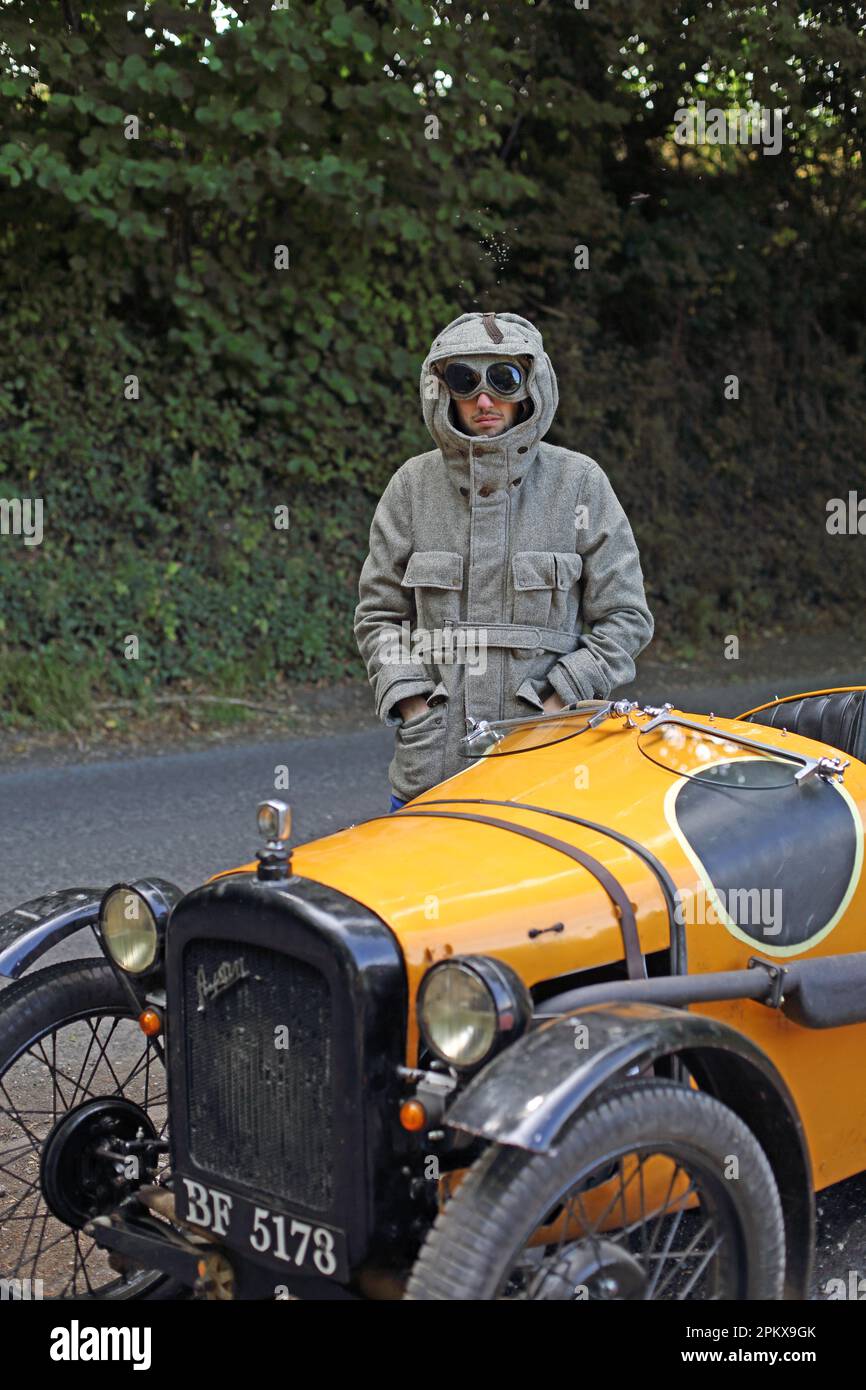 Viaggio in auto d'epoca Austin 7 uomo con occhiali vintage guardare guida su una strada di campagna in Inghilterra . Foto Stock