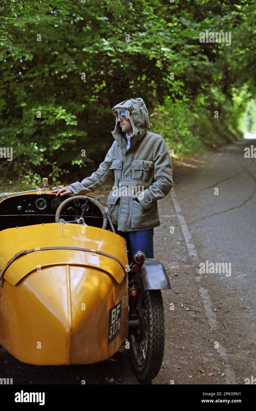 Viaggio in auto d'epoca Austin 7 uomo con occhiali vintage guardare guida su una strada di campagna in Inghilterra . Foto Stock