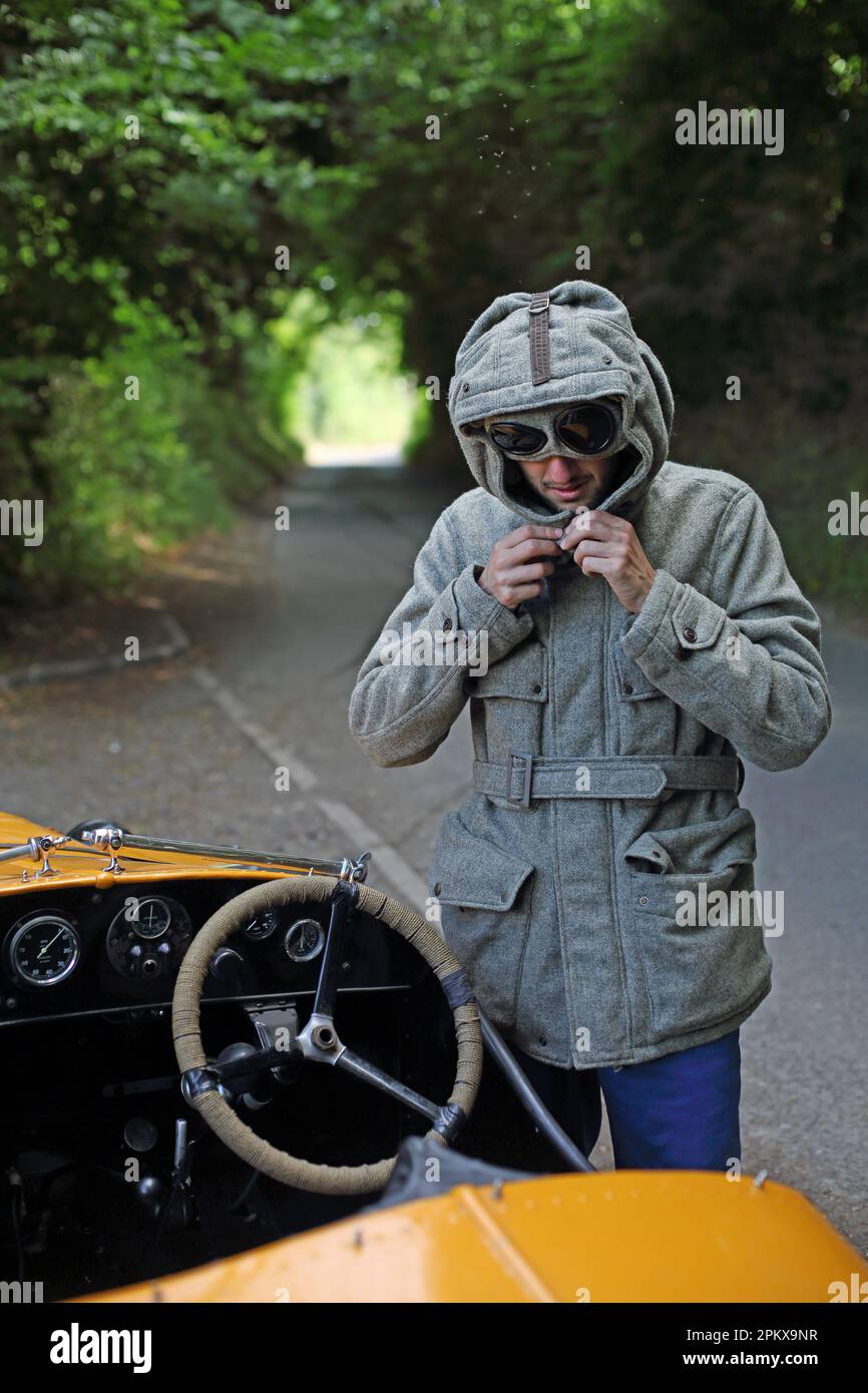 Viaggio in auto d'epoca Austin 7 uomo con occhiali vintage guardare guida su una strada di campagna in Inghilterra . Foto Stock