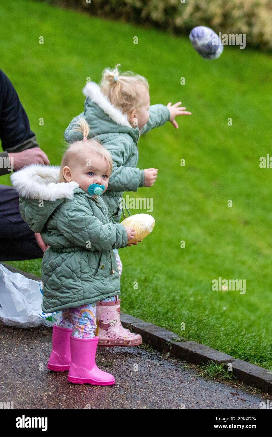 Preston Lancashire. Meteo nel Regno Unito. 10 aprile 2023. Heidi 3 anni e sorella Olivia 18 mesi al tradizionale Lunedì di Pasqua Rolling delle uova nel Parco Avenham, una tradizione che risale al 1867. I bambini rotolano le loro uova di passo giù le colline e vedono chi potrebbe ottenere loro il più lontano senza rompersi. Credit MediaWorldmages/AlamyLiveNews Foto Stock