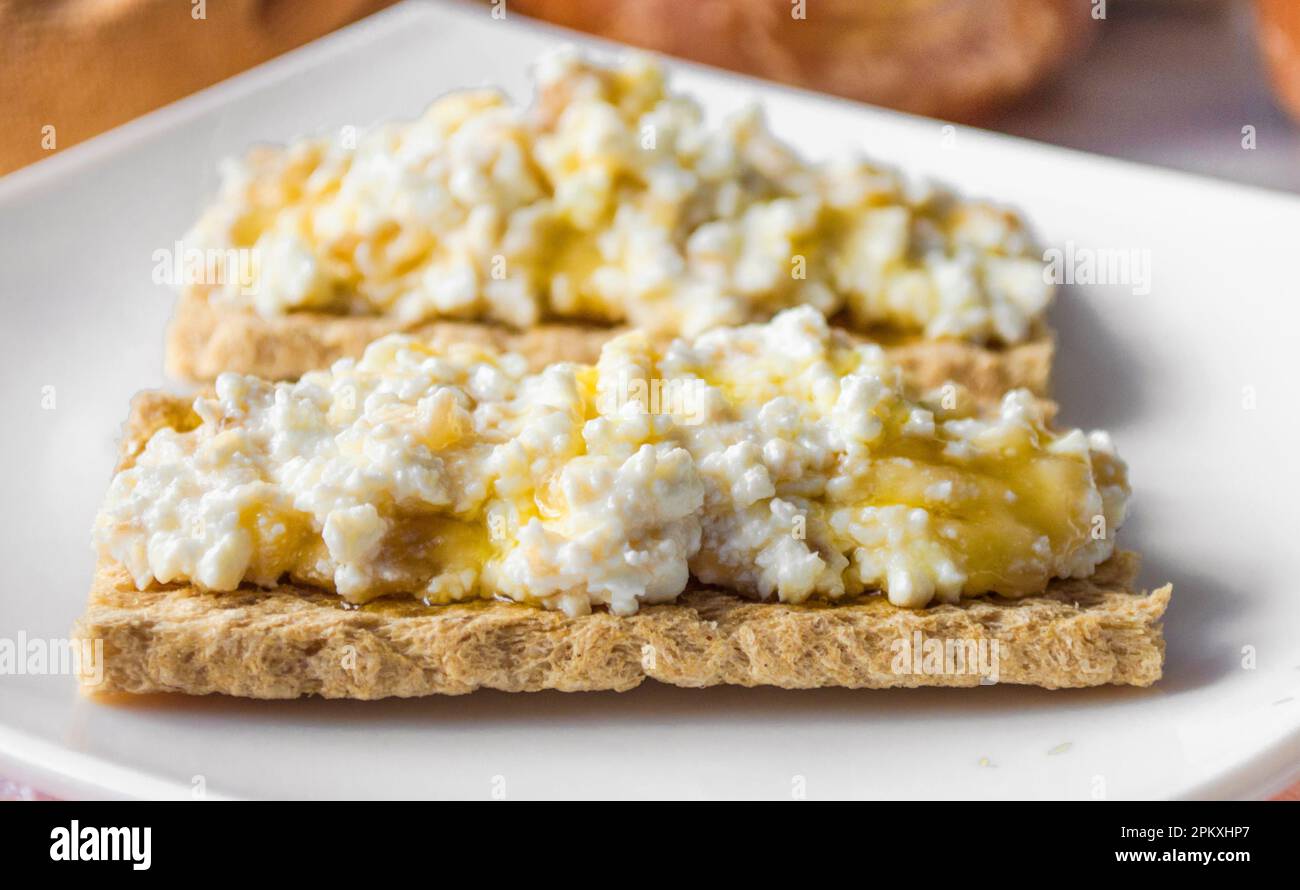 Colazione a base di pane dietetico con formaggio casolare e miele Foto Stock