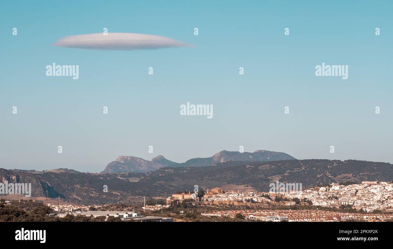 Nuvola a forma di UFO nel cielo blu chiaro sopra Ronda Foto Stock