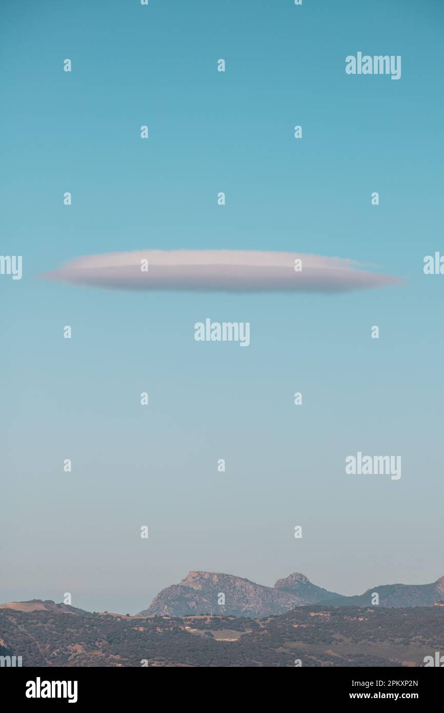 Nuvola a forma di UFO nel cielo blu chiaro sopra Ronda Foto Stock