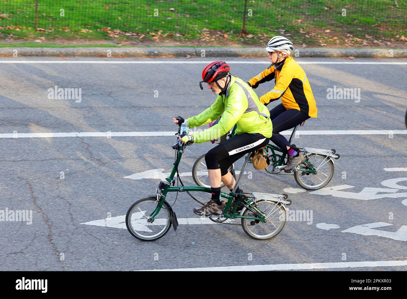 Una coppia più anziana in bicicletta pieghevole Brompton. Anziani attivi in bicicletta. Foto Stock