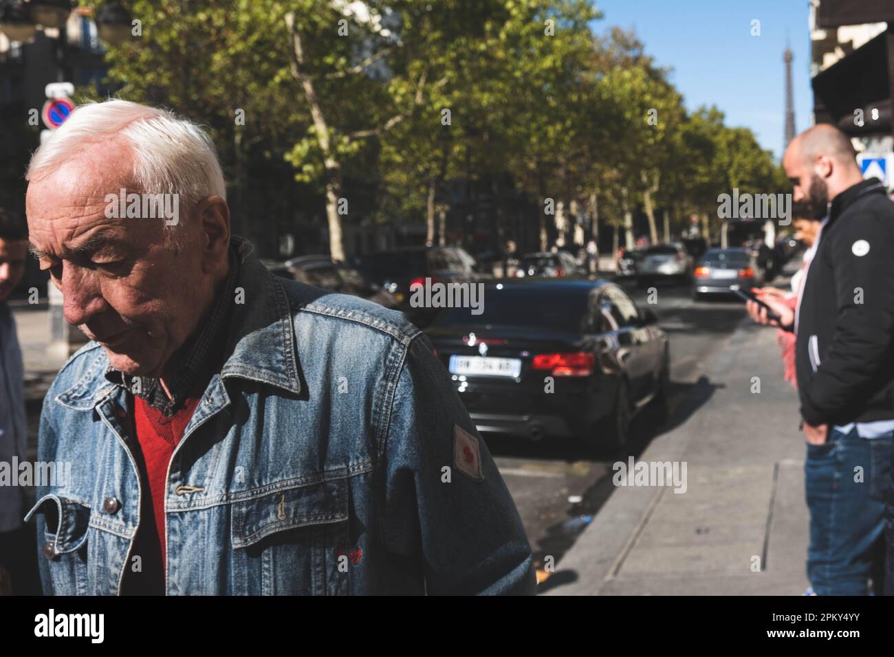 Giacca uomo dai capelli bianchi in jeans catturata con la Torre Eiffel in lontananza Foto Stock