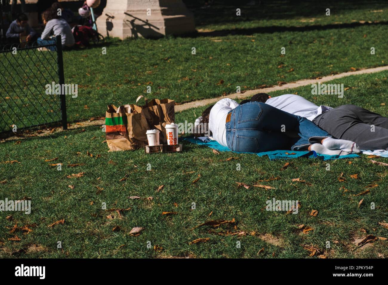 Couple Falls dorme sull'erba dopo aver gustato un pasto Burger King Foto Stock