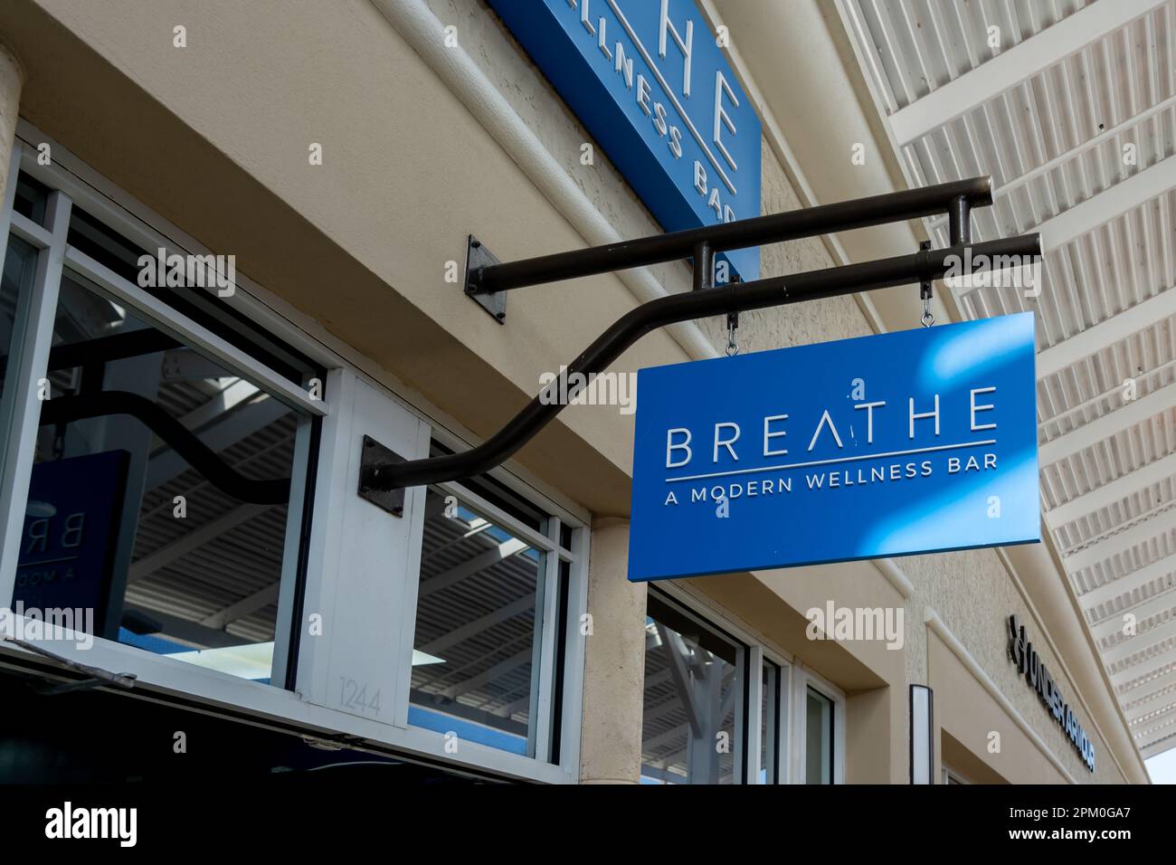 Viene mostrato un primo piano del moderno cartello sospeso del Breathe Wellness Bar. Foto Stock