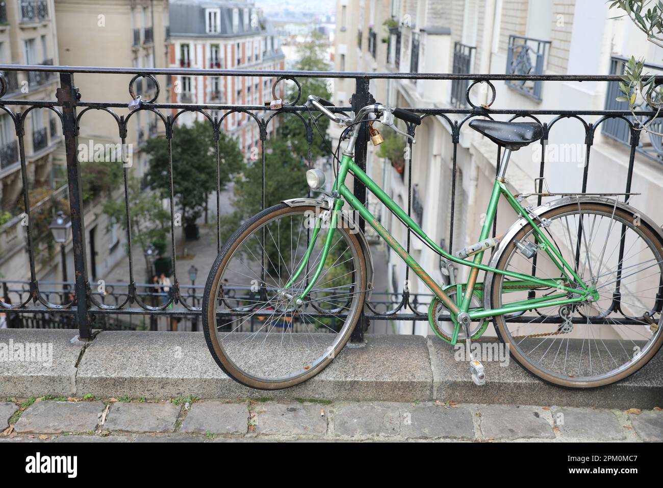 Parigi, Francia, 29 ottobre 2022: Una bicicletta Motobecane verde vintage si appoggia contro una ringhiera su una strada in pendenza nello storico quartiere di Montmartre Foto Stock