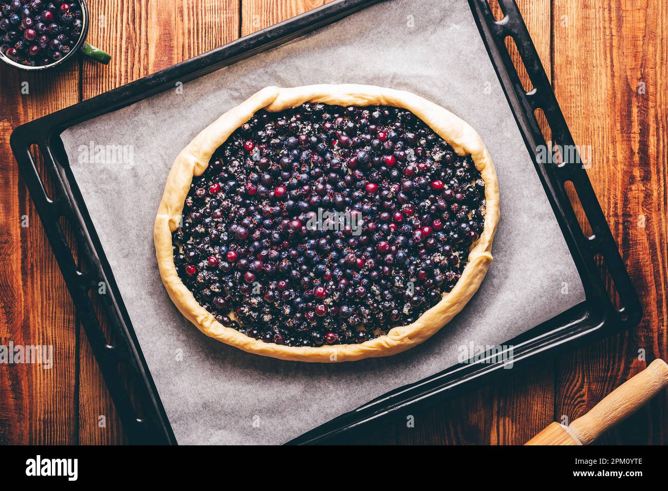 Pronti per la cottura delle Berries di Amelanchier aprire la torta sulla teglia da forno. Vista dall'alto Foto Stock