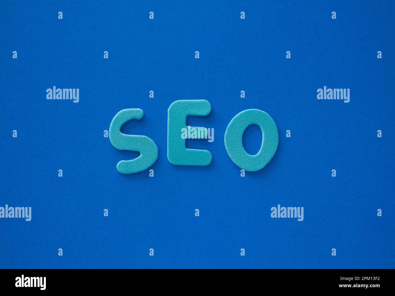 La parola SEO fatto da lettere blu su uno sfondo blu. Lettere blu come SEO abbreviazione Search Engine Optimization . Foto Stock