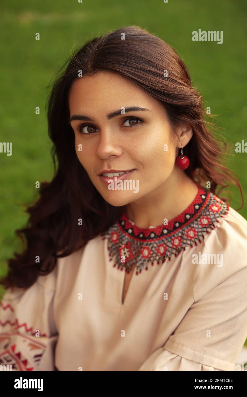 Bella donna che indossa una collana decorata con perline e orecchini rossi all'aperto. Gioielli nazionali ucraini Foto Stock