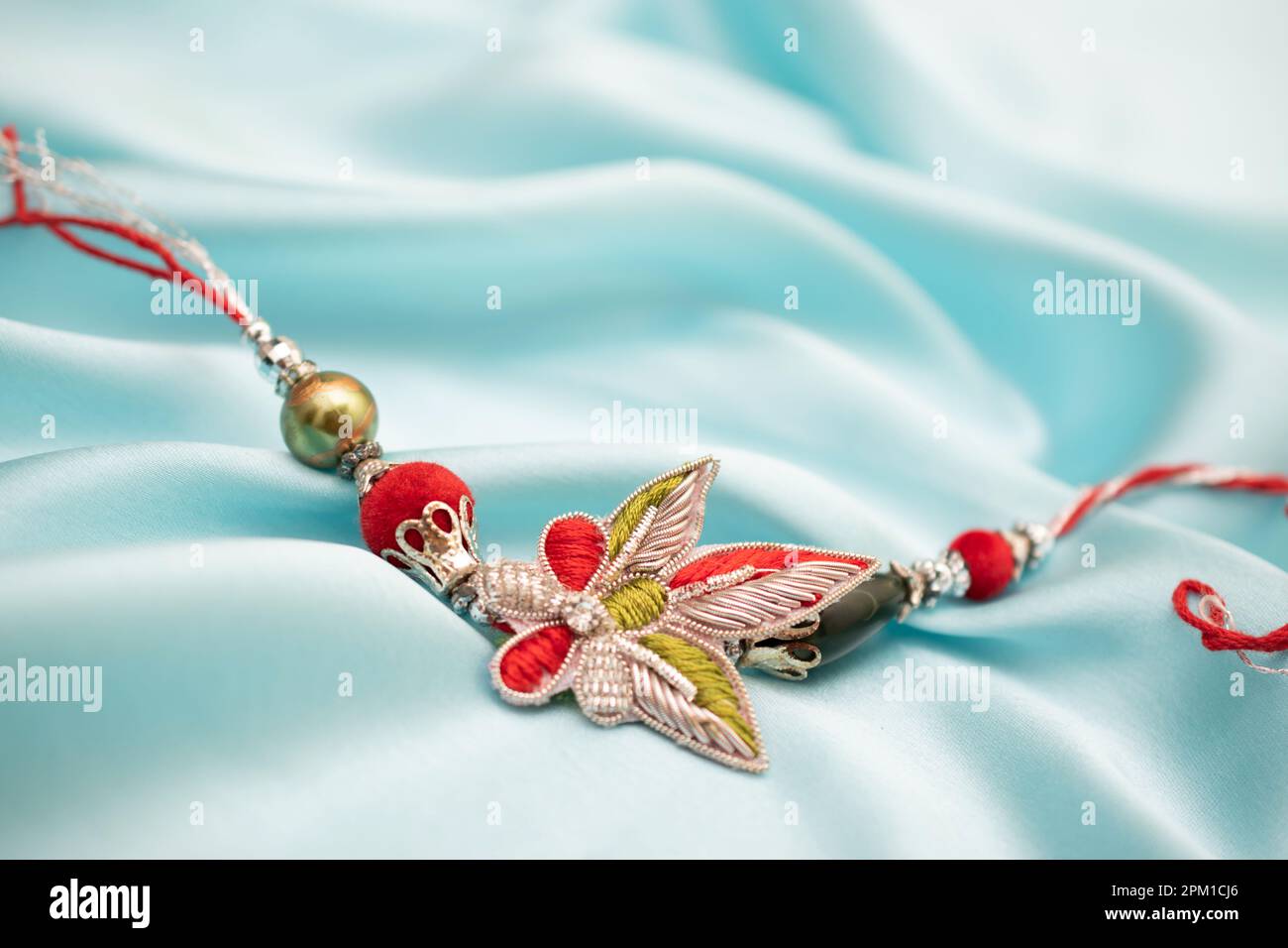 Bellissimo rakhi fatto a mano su sfondo di seta blu Foto Stock