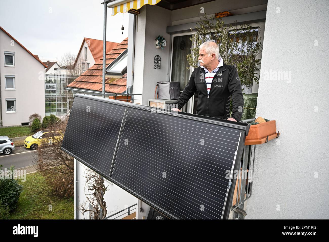 Konstanz, Germania. 25th Jan, 2023. Michael Breuninger si trova sul balcone del suo appartamento, dove sono montati pannelli solari. (Scatto con treppiede alto) Credit: Felix Kästle/dpa/Alamy Live News Foto Stock