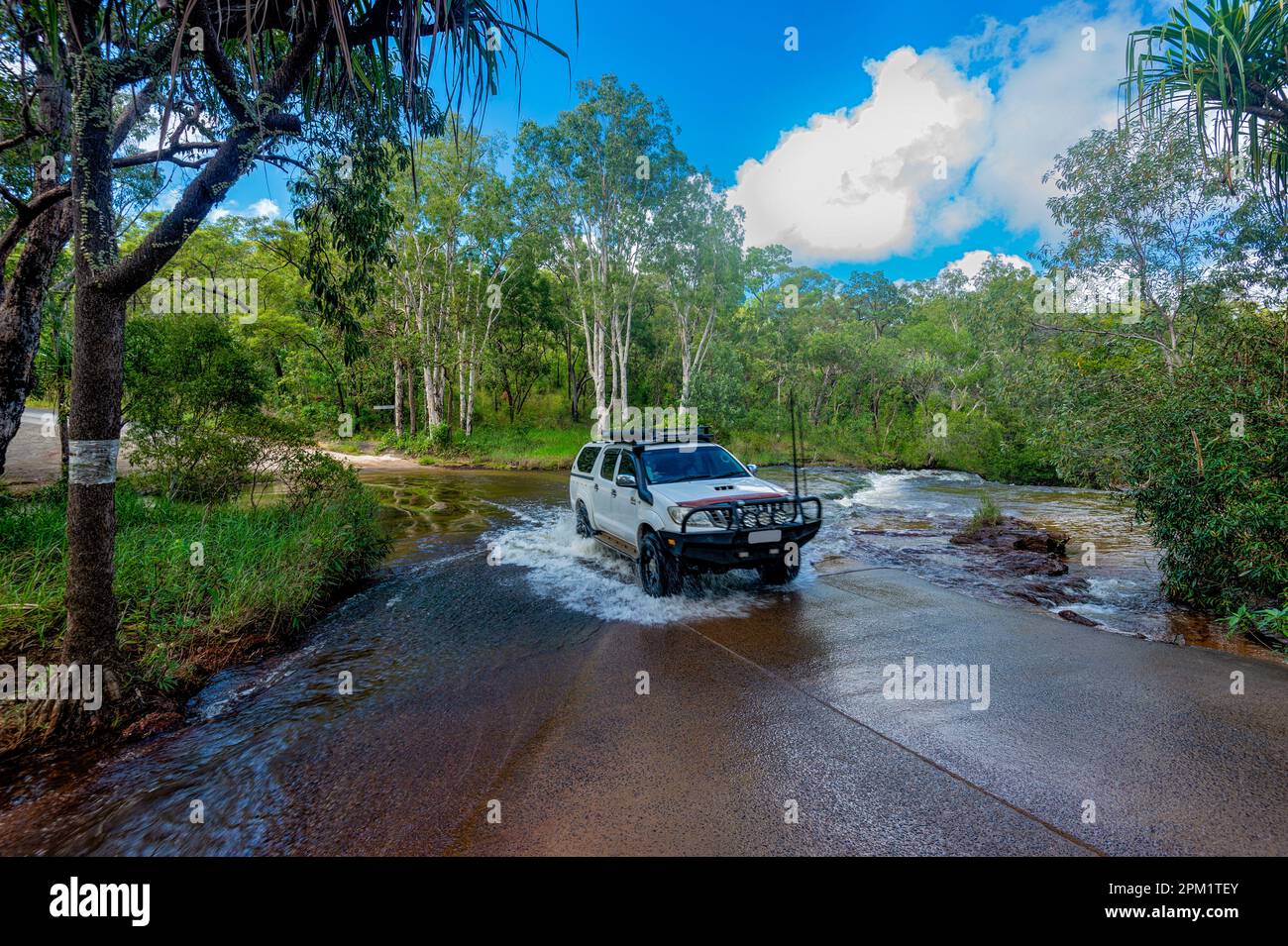 A 4WD Toyota Hilux attraversando Isabella Falls Creek, un'attrazione turistica in far North Queensland, FNQ, QLD, Australia Foto Stock