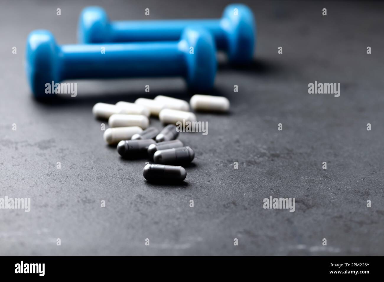 Capsule di BCAA e creatie. Bodybuilding integratori alimentari su sfondo di pietra scura. Messa a fuoco morbida. Primo piano. Spazio di copia. Foto Stock