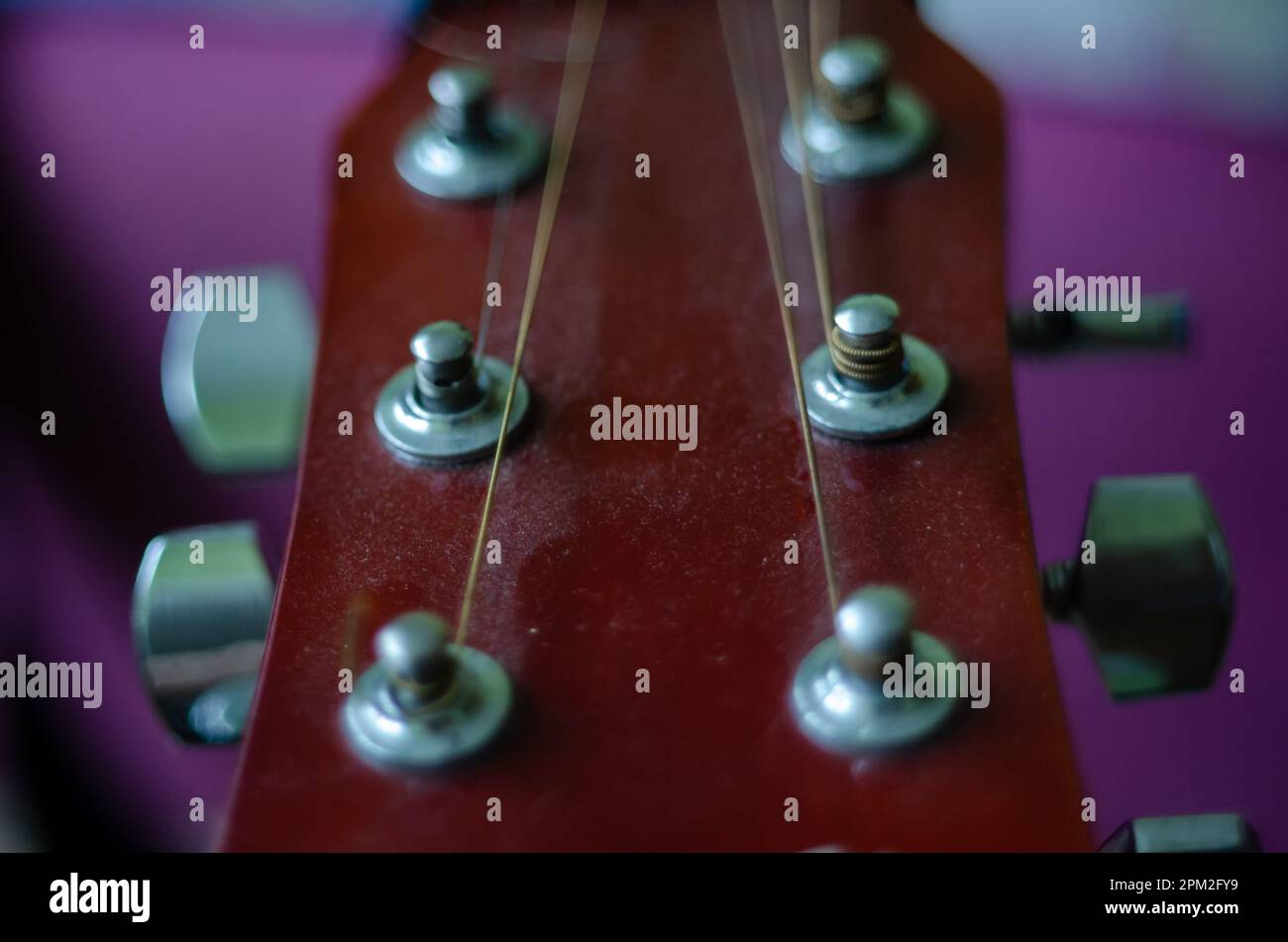 Un'immagine del collo di una chitarra acustica con dettagli intricati e finiture lucide Foto Stock