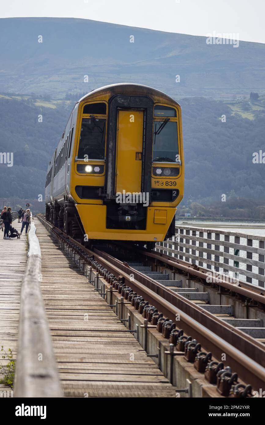 BARMOUTH, GWYNEDD UK - 09 APRILE : treno che viaggia sul viadotto di Barmouth, Gwynedd il 09 aprile 2023. Persone non identificate Foto Stock