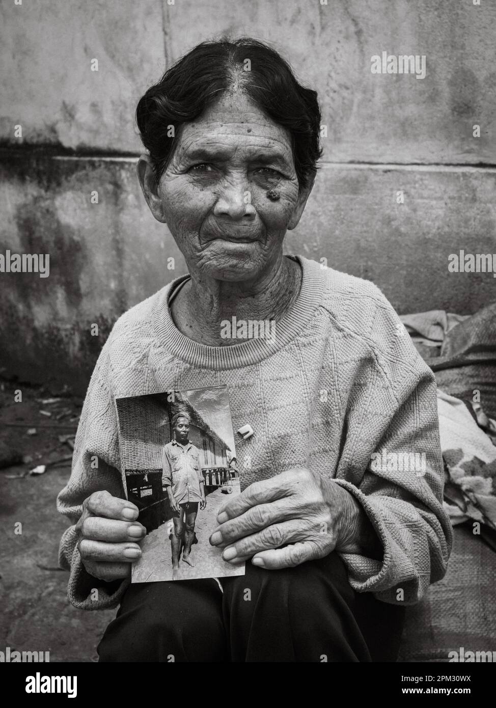 Una vedova anziana della minoranza etnica Jerai negli altopiani centrali del Vietnam, tiene una fotografia del suo defunto marito, il capo del villaggio, presa Foto Stock