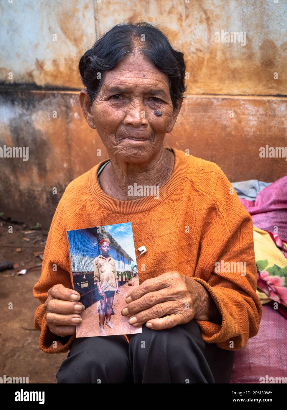 Una vedova anziana della minoranza etnica Jerai negli altopiani centrali del Vietnam, tiene una fotografia del suo defunto marito, il capo del villaggio, presa Foto Stock