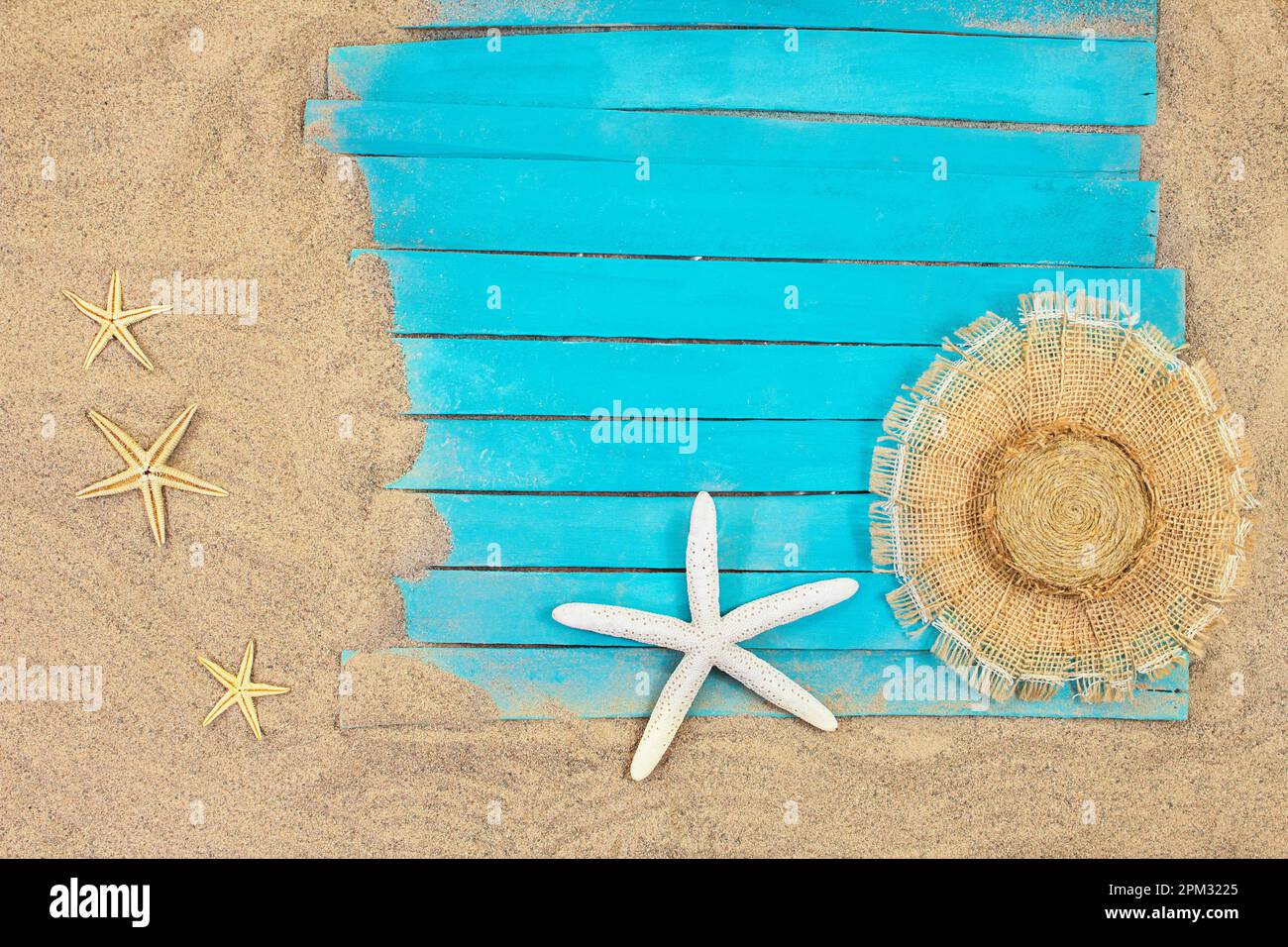 Stelle marine bianche e arancioni con cappello di paglia su pedane blu rustiche in legno nautico. Estate, mare sfondo. Concetto di viaggio, vacanza. Spazio di copia Foto Stock