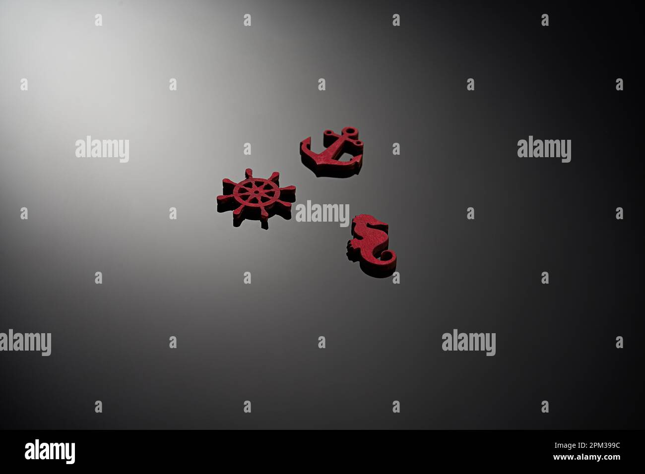 Un set di tre piccole statuine di legno rosso su uno sfondo nero. Foto Stock