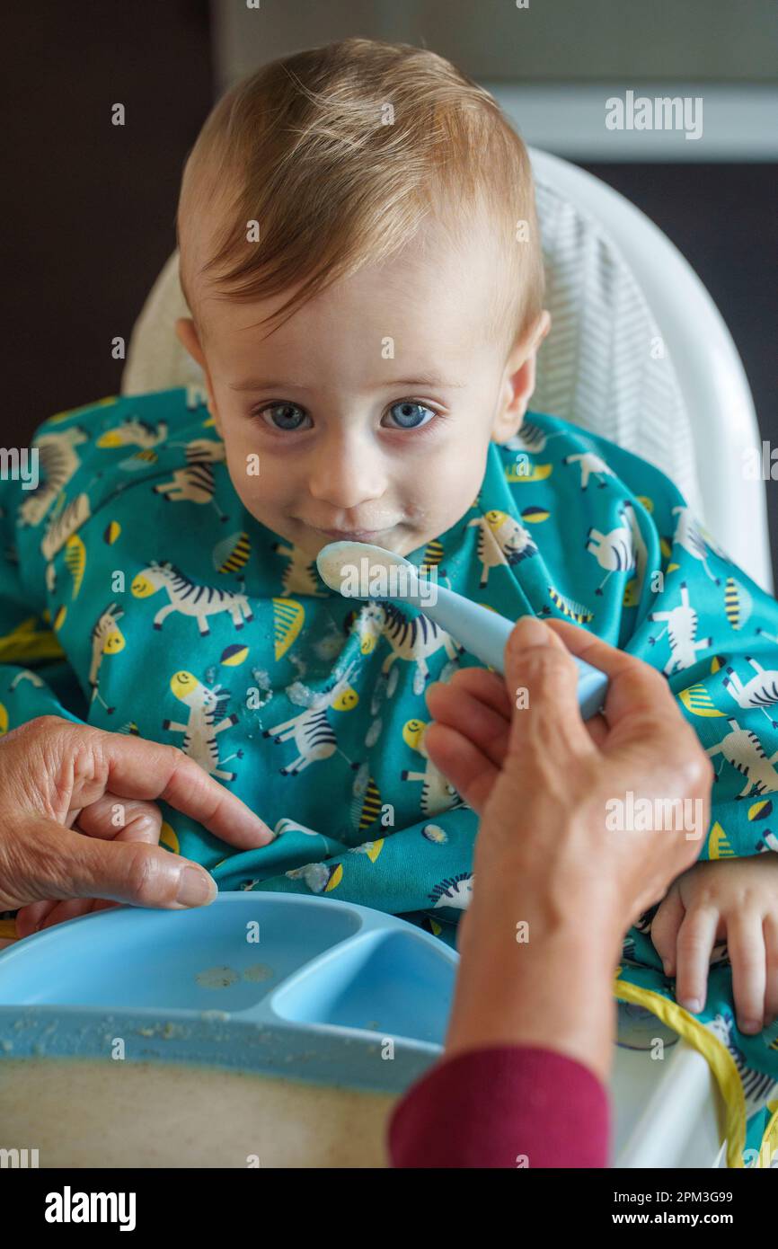 Nonna che alimenta il suo nipote sorridente Foto Stock