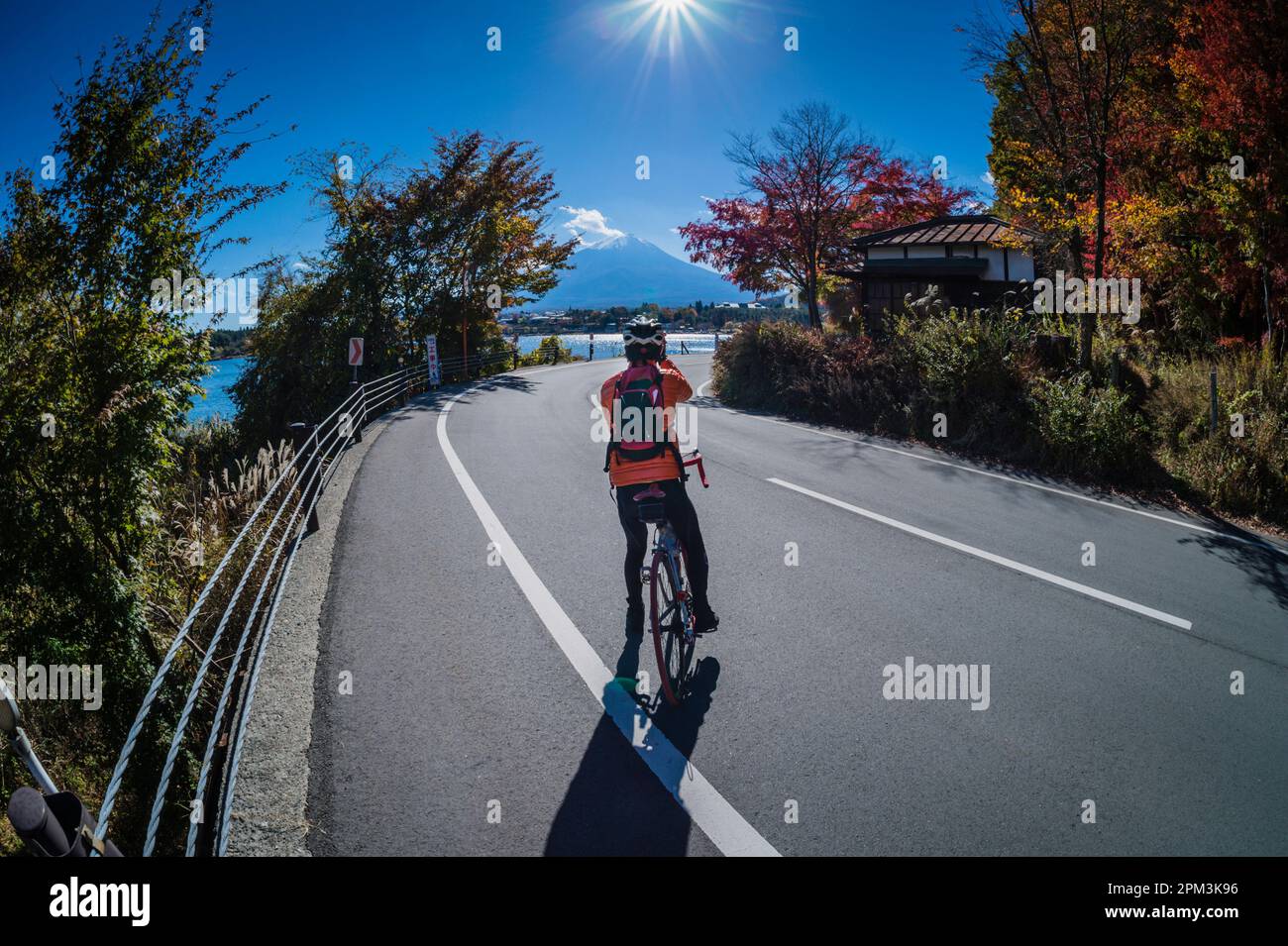 Il ciclista giapponese si ferma per scattare una foto sulle rive del lago Kawaguchi del Monte Fuji. Foto Stock