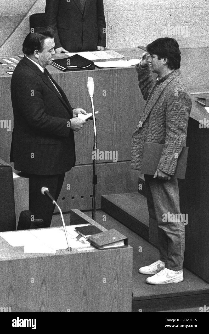 ARCHIVIATO - 12 dicembre 1985, Assia, Wiesbaden: Joschka Fischer (r, i Verdi) indossa scarpe da ginnastica come giurato come Ministro per l'ambiente e l'energia nel parlamento di Stato da Holger Börner (CDU), allora primo Ministro dell'Assia. Fischer, portavoce del gruppo parlamentare Alleanza 90/Verdi nel Bundestag tedesco dal 1994 al 1998, e ministro degli Esteri e vice cancelliere tedesco dal 1998 al 2005, è nato a Gerabronn, Baden-Württemberg, il 12 aprile 1948. Foto: Immagine alleanza/dpa Foto Stock
